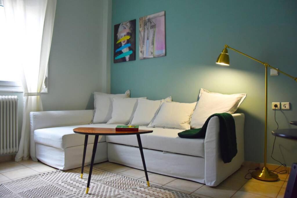 City Life Apartments #3 في يوانينا: غرفة معيشة مع أريكة بيضاء وطاولة