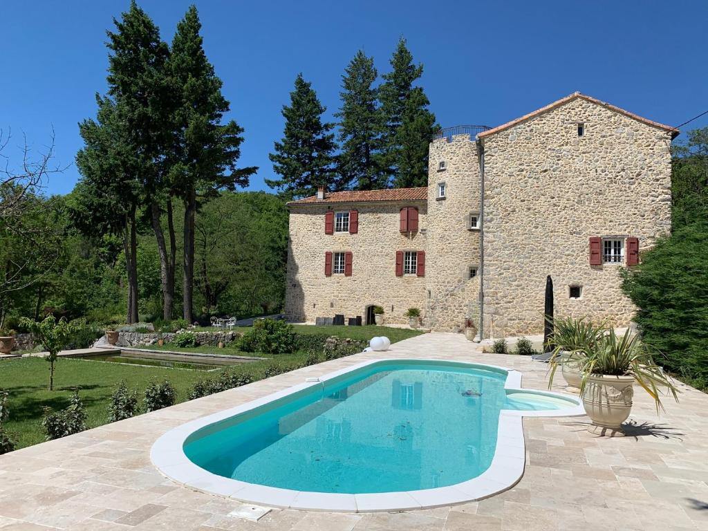 a house with a swimming pool in front of a building at Chateau de la Rode in Aumessas