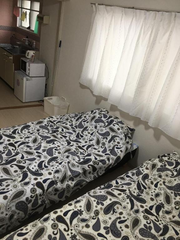 - une chambre avec un lit et une couette noire et blanche dans l'établissement Utopia Wakamiya 207 / Vacation STAY 5372, à Fukuoka