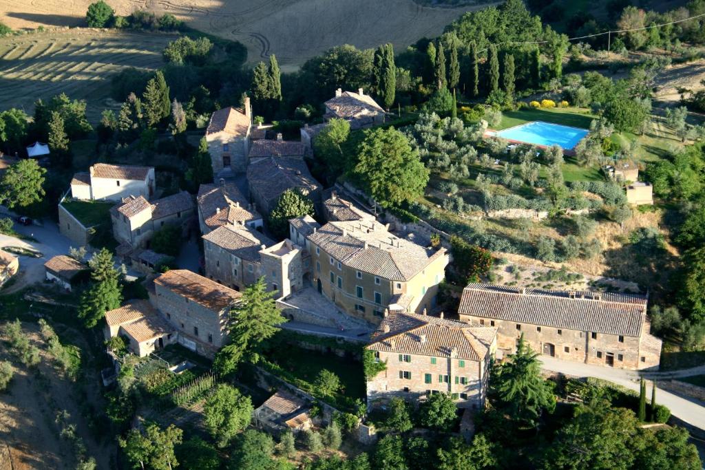 vista aerea su un palazzo con piscina di Borgo Lucignanello Bandini a San Giovanni dʼAsso