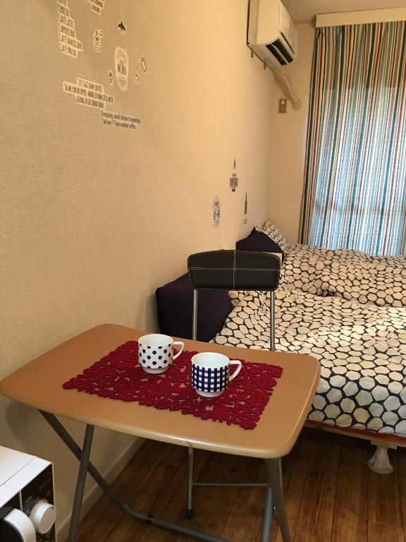 Una habitación con una mesa con dos tazas. en Utopia Wakamiya No.105 / Vacation STAY 5161 en Fukuoka