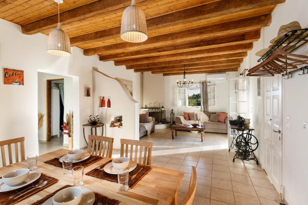 cocina y sala de estar con mesa de madera y sillas en fridas place, en Halikounas
