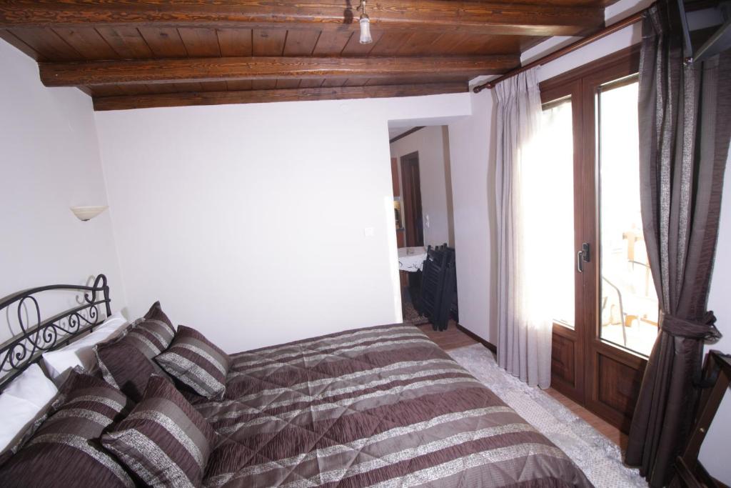 A bed or beds in a room at Xenonas Orizontes