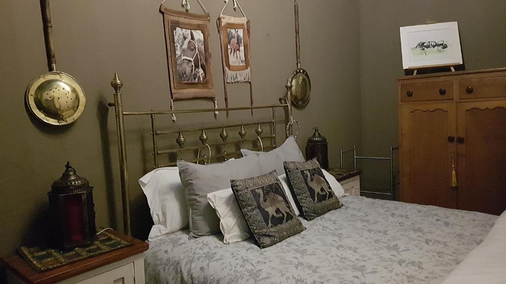 ein Schlafzimmer mit einem Bett mit Kissen darauf in der Unterkunft Wooden Creek Estate in Kempton Park