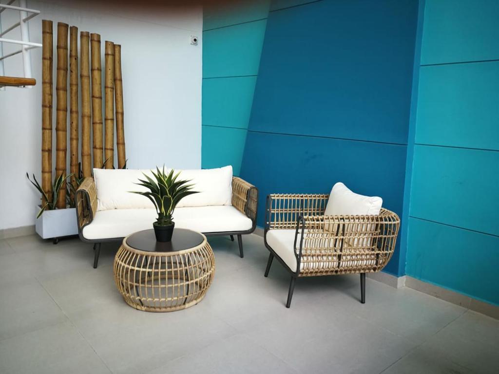 una habitación con 2 sillas y una mesa con una maceta en Acogedor Wind Playa Salguero frente al mar, en Santa Marta