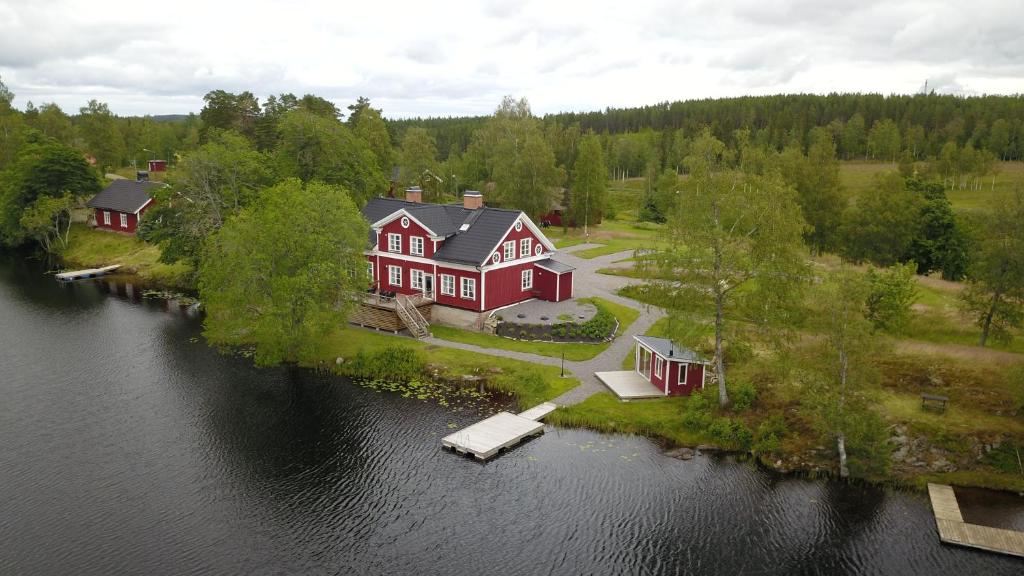an aerial view of a large red house on a lake at River Lodge in Ludvika