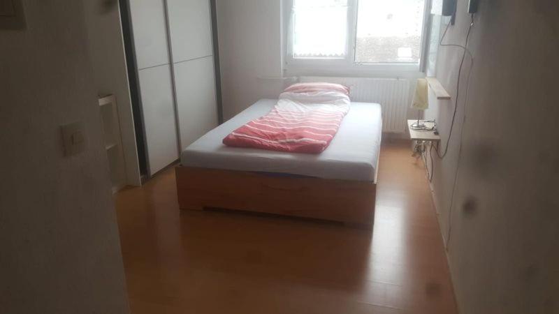 a small bed in a room with a wooden floor at Appartement Altstadt Mainz in Mainz