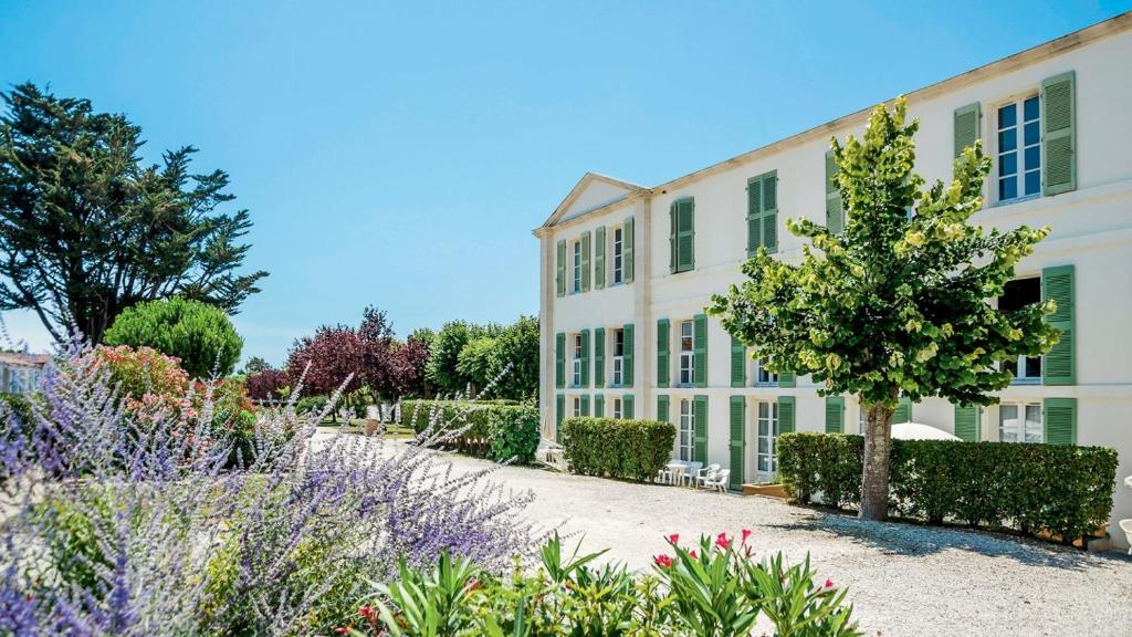 a building with a garden in front of it at Appartement les gouverneurs in Saint-Martin-de-Ré