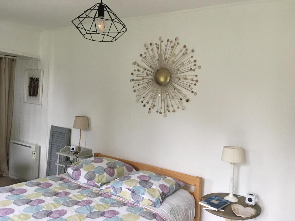 een slaapkamer met een bed en een spiegel aan de muur bij Studio Vue Mer - Idéal Voyageur Solo, à Vélo, à Pied in Perros-Guirec