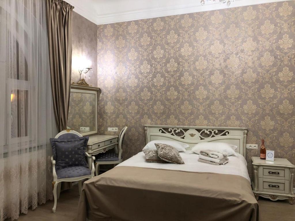 um quarto com uma cama, uma secretária e uma cadeira em Dolce Vita Apartments em Mariánské Lázně