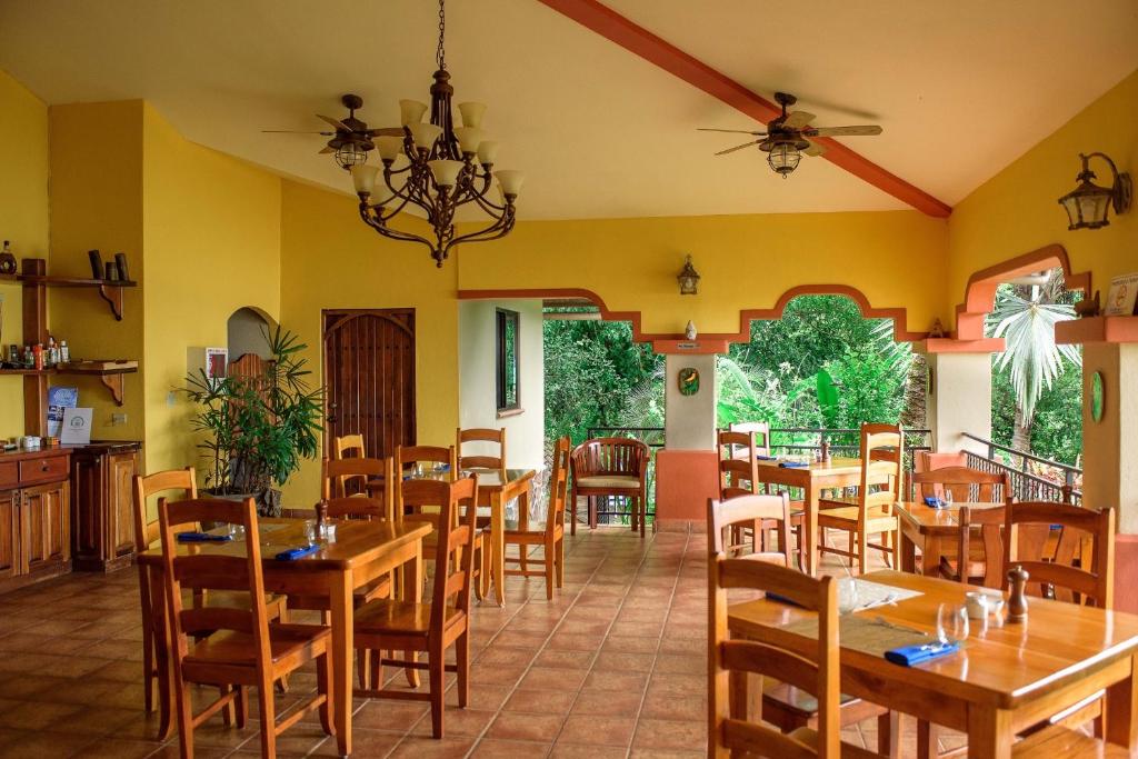 comedor con mesas y sillas de madera en Seagull Cove Resort, en Boca Chica