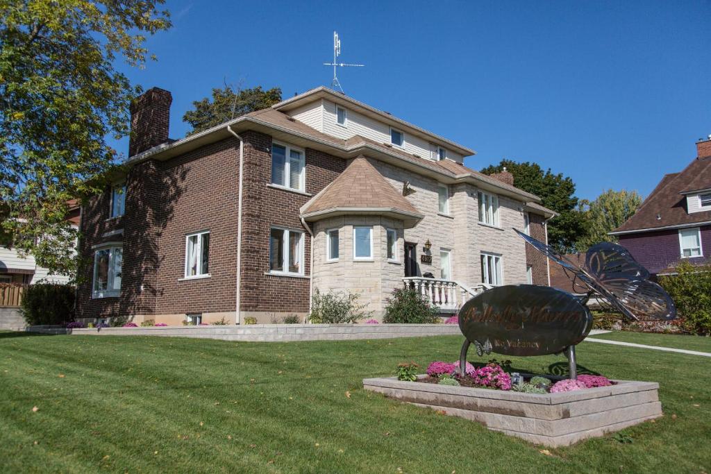 una casa grande con un cartel delante en Butterfly Manor, en Niagara Falls