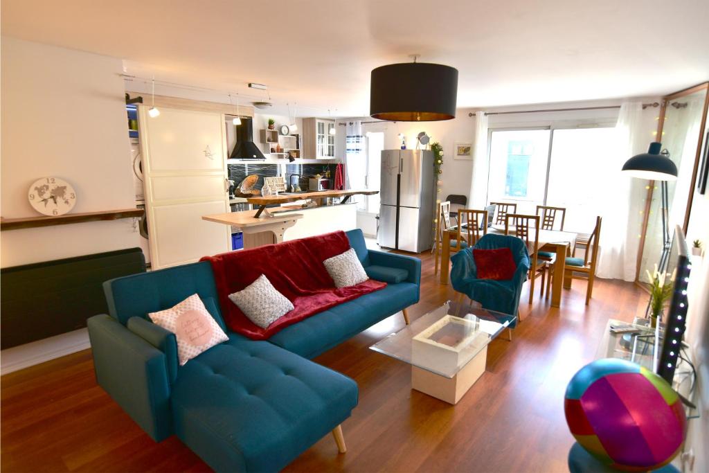 a living room with two blue couches and a kitchen at Appartement luxueux 100m² Bordeaux in Le Bouscat