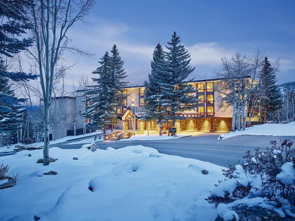 uma casa na neve com árvores cobertas de neve em Stonebridge Inn em Snowmass Village