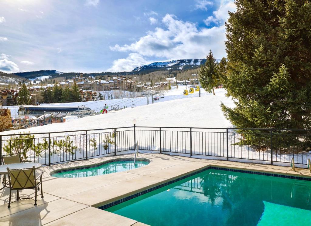 a swimming pool with a ski slope in the background at Lichenhearth - CoralTree Residence Collection in Snowmass Village