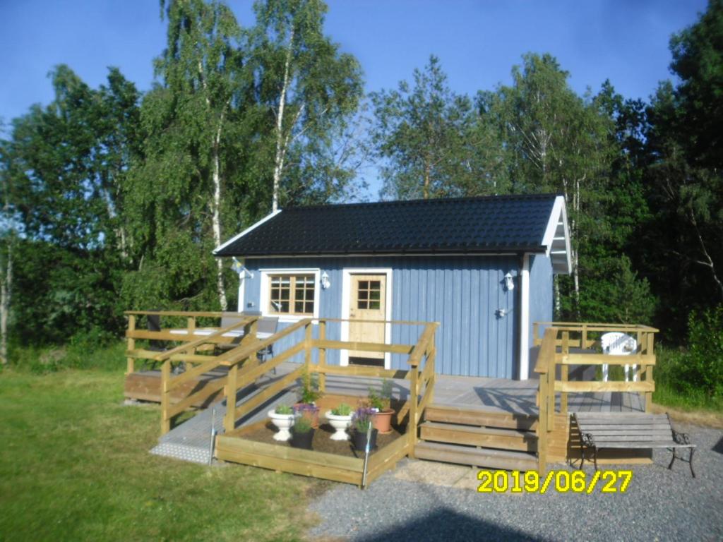 um pequeno barracão com um deque e um banco em Lussebo 9 em Lidköping