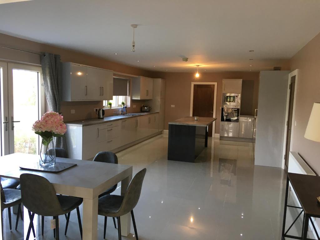 a kitchen and dining room with a table and chairs at Wainsfort House in Blacklion