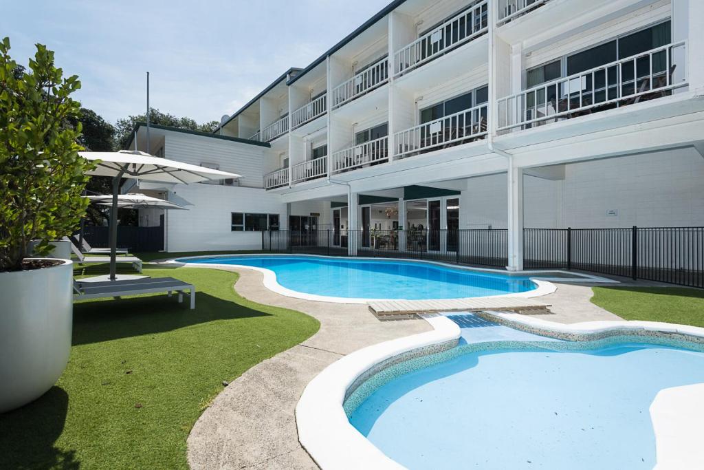 a swimming pool in front of a building at Hotel Armitage and Conference Centre in Tauranga