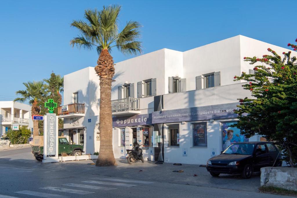 a palm tree in front of a white building at Parikia's Crossroad 3 Bedroom House in Kampos Paros