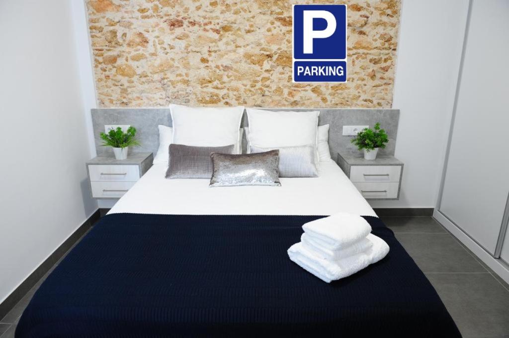 1 dormitorio con 1 cama blanca grande y toallas. en LUZ DEL FARO, en Cádiz
