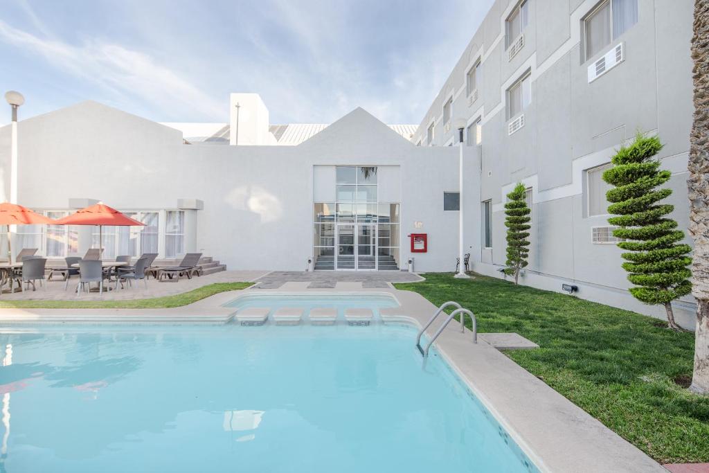 une piscine en face d'un bâtiment dans l'établissement Casa Grande Delicias, à Delicias