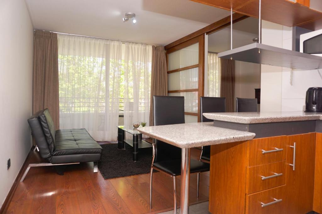 a kitchen with a counter and a table and chairs at Bellavista Travel Suites in Santiago