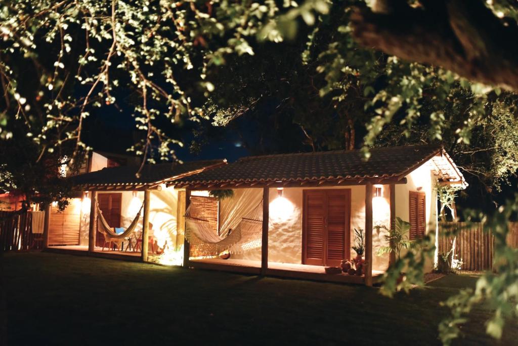 uma casa iluminada à noite com luzes em Casa Pitanga - Caraíva em Caraíva