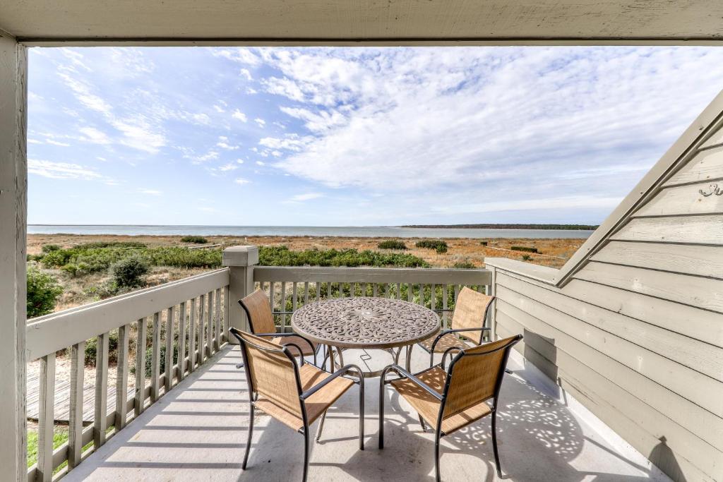 a table and chairs on a balcony with a view of the ocean at 1378 Pelican Watch Villa in Seabrook Island