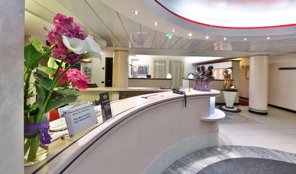 a lobby with a vase of flowers on a counter at Best Western Hotel Solaf in Medolago