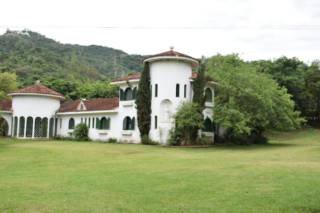een groot wit huis met een grote tuin bij Chácara Dona Eulália in Monte Alegre do Sul