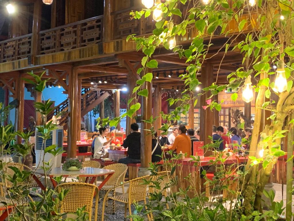 eine Gruppe von Menschen, die an Tischen in einem Restaurant sitzen in der Unterkunft Maison Teahouse homestay in Ha Giang