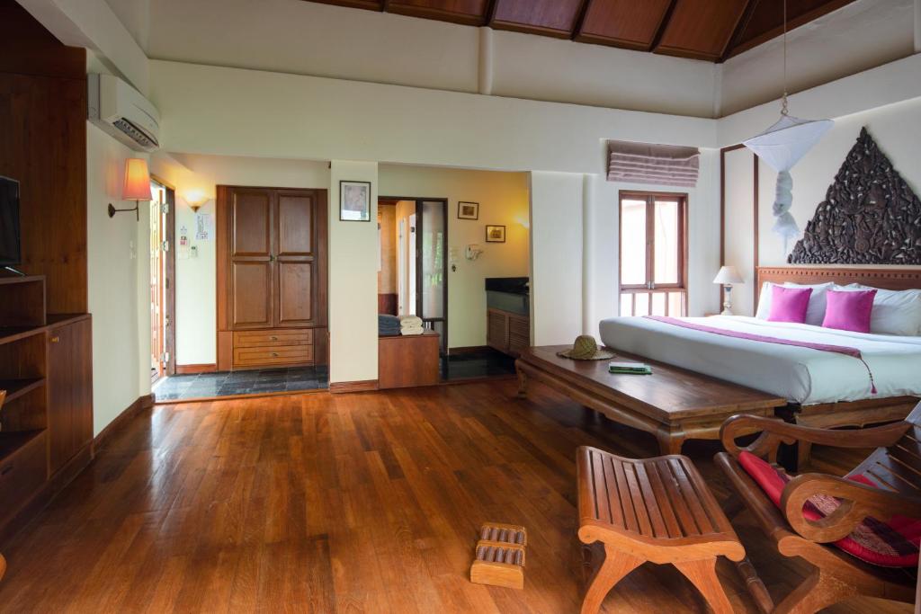 a bedroom with a large bed and a wooden floor at Royal Lanta Resort & Spa in Ko Lanta