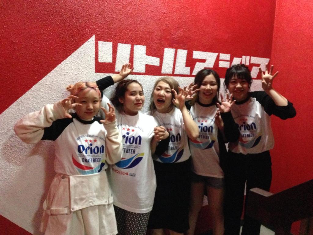 a group of girls standing in front of a wall at Little Asia Guest House in Naha