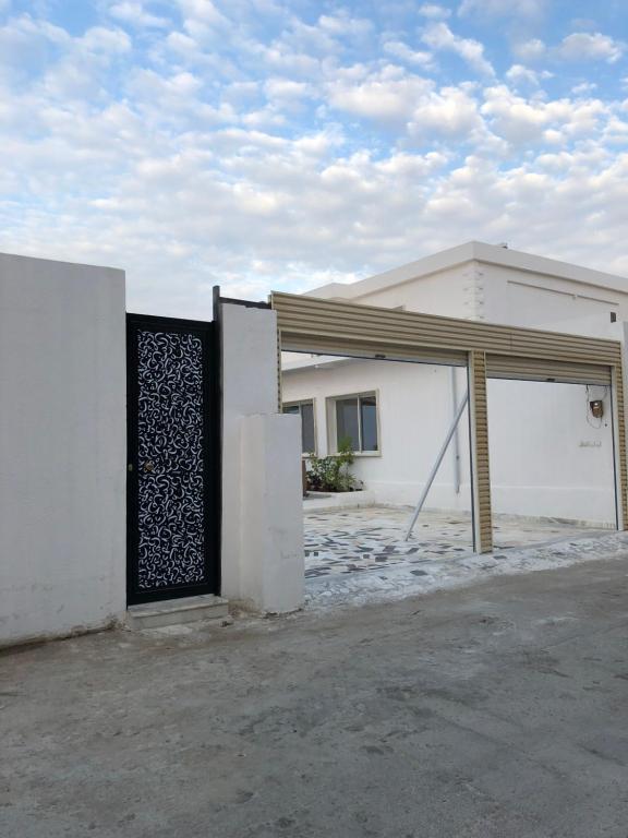 biały budynek z bramą i garażem w obiekcie سمو1 w Rijadzie