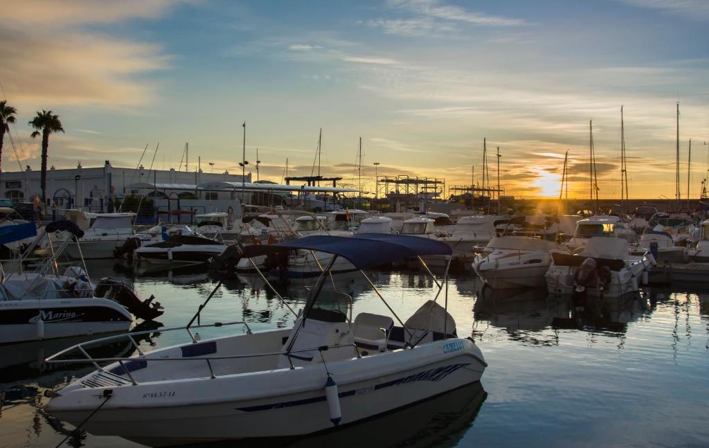 grupa łodzi zakotwiczona w przystani o zachodzie słońca w obiekcie Magnificent Port-Beach 5* Luxury Residence w mieście Benalmádena