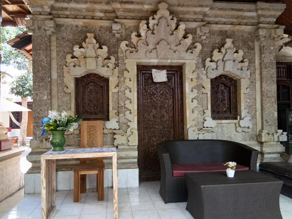 une terrasse avec un canapé, une table et des chaises dans l'établissement Griya Nusa, à Nusa Penida