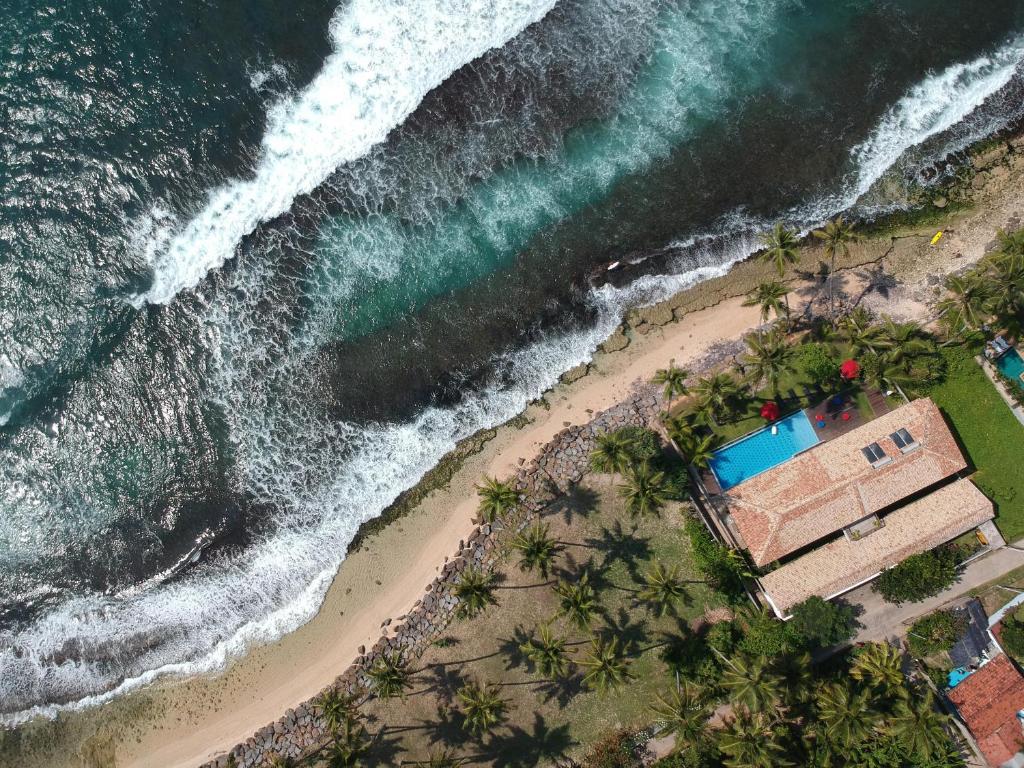 an aerial view of a beach with a building and the ocean at Villa Océane in Mirissa