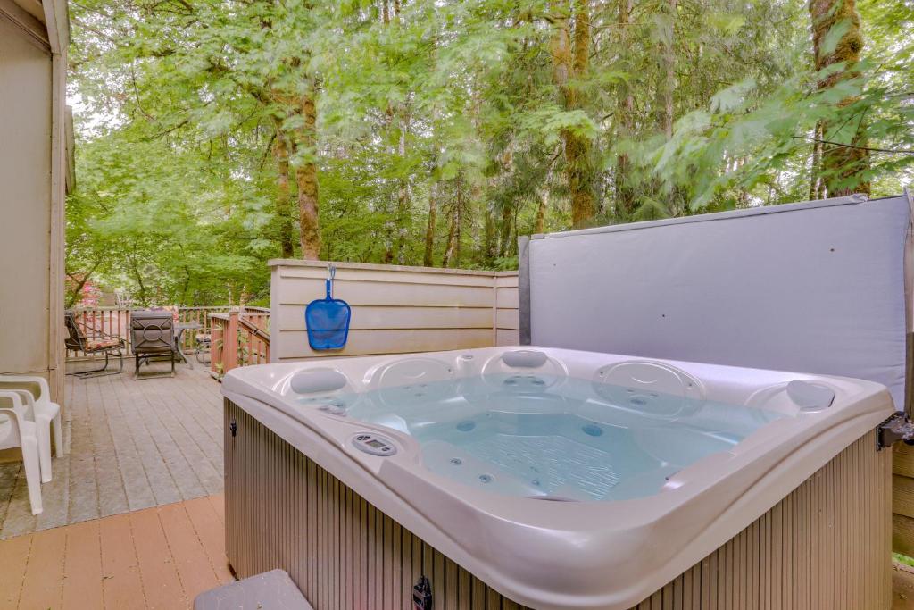 a jacuzzi tub on a patio with trees at Clark's Mountain Condo in Welches