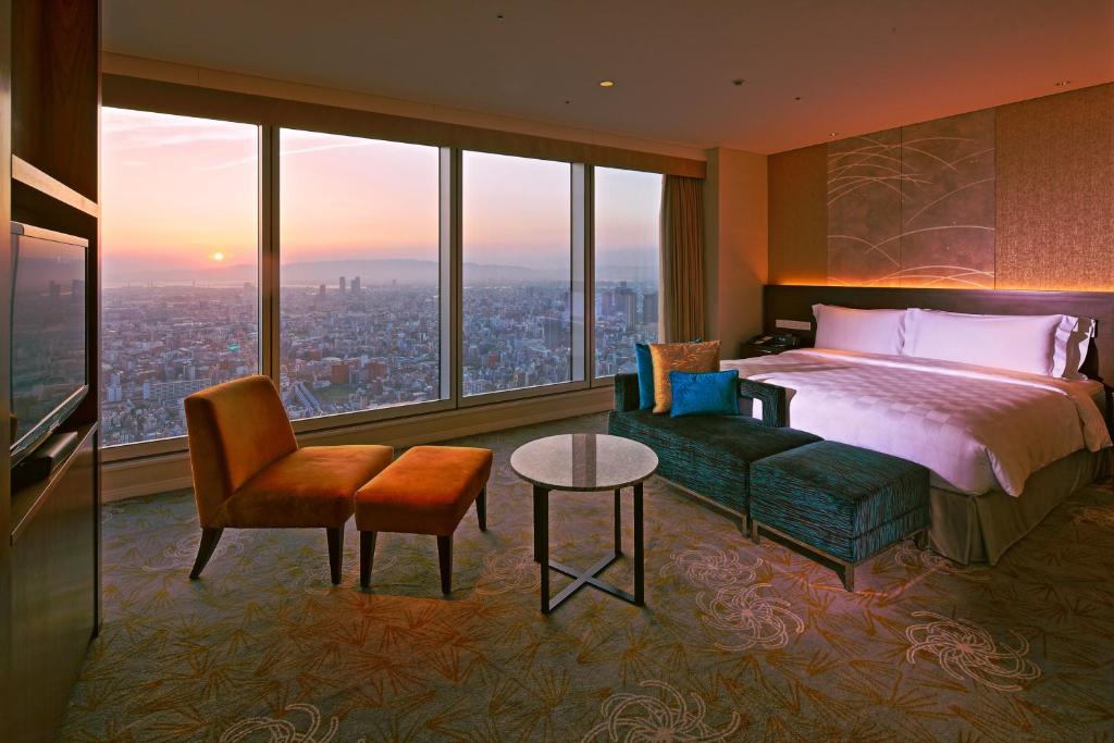 a bedroom with a bed and a couch and a table at Osaka Marriott Miyako Hotel in Osaka