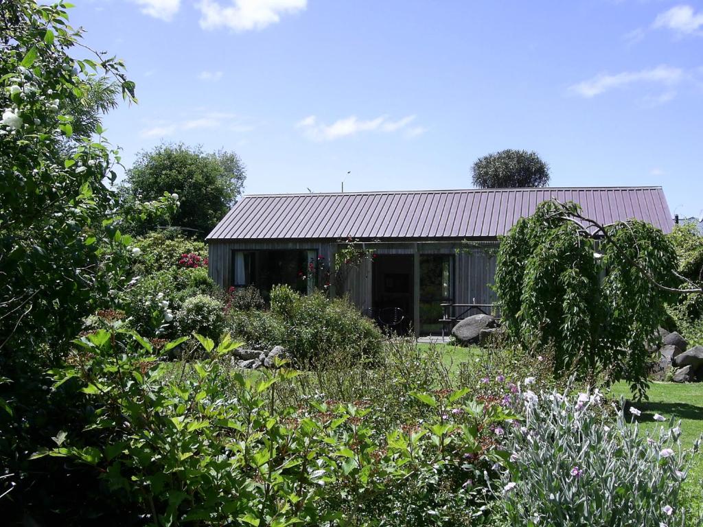 una casa con un jardín delante de ella en Down South Cottage en Invercargill