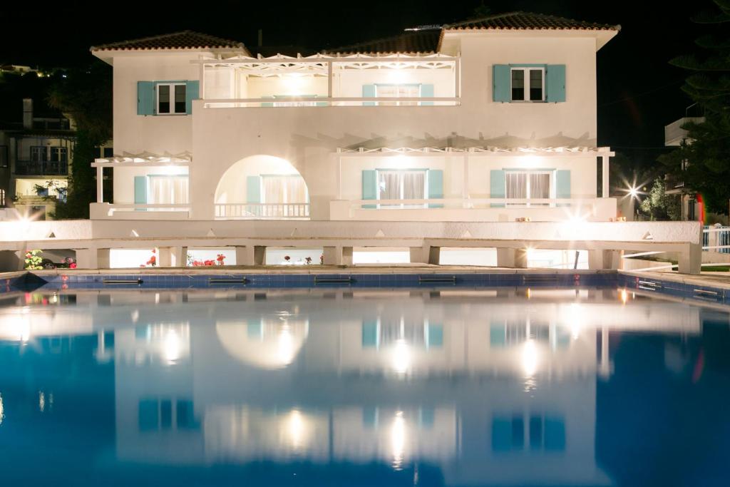 a large white swimming pool in front of a large white building at Sunrise Village Hotel Apartments in Skopelos Town
