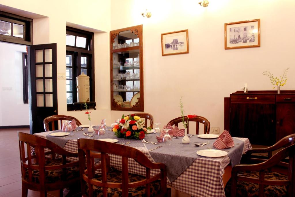 a dining room with a table with flowers on it at Lake Palace in Thekkady