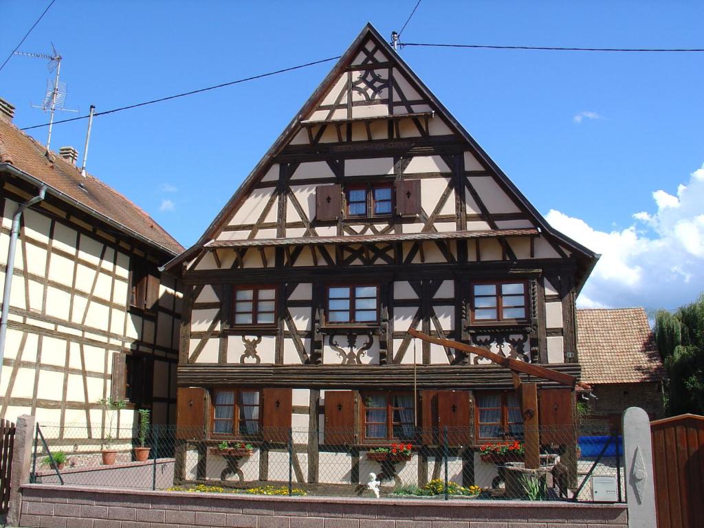 ein altes Gebäude mit Fachwerk in der Unterkunft Gite d'Audrey et Jean in Uttenheim