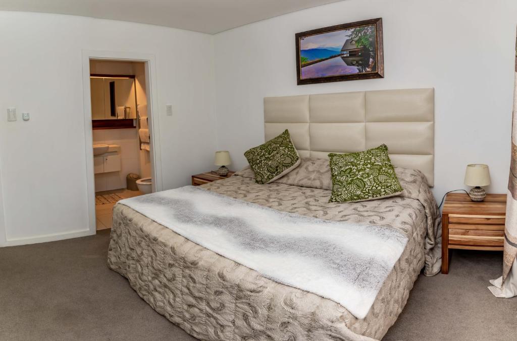 a bedroom with a large bed with green pillows at Zimbali Suite 213 in Ballito