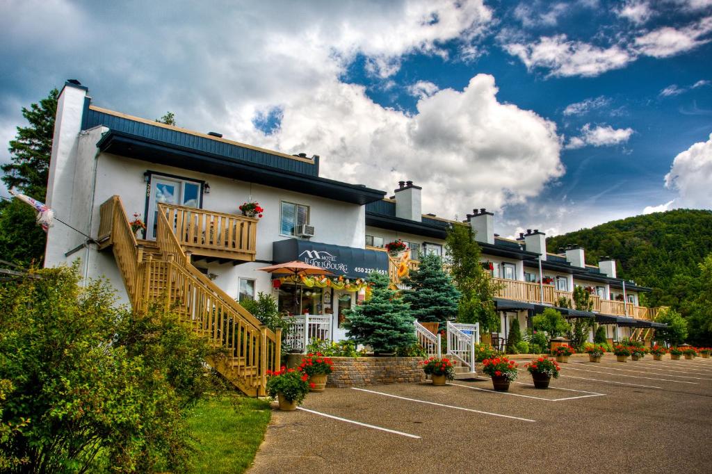 um hotel com um parque de estacionamento em frente em Motel Le JoliBourg em Saint-Sauveur-des-Monts