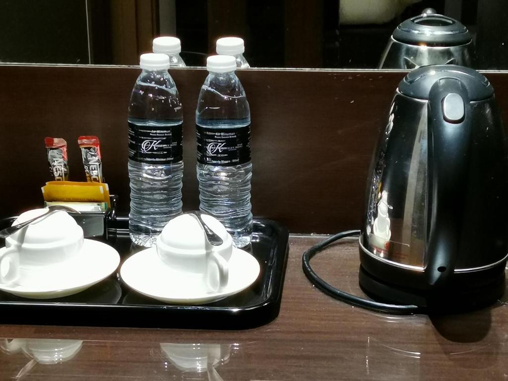 a tray with two bottles of water and a tea kettle at Kimberley Hotel Georgetown in George Town