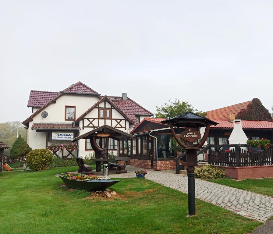 a large house with a sign in the grass at Pension Haus zum See in Markische Heide