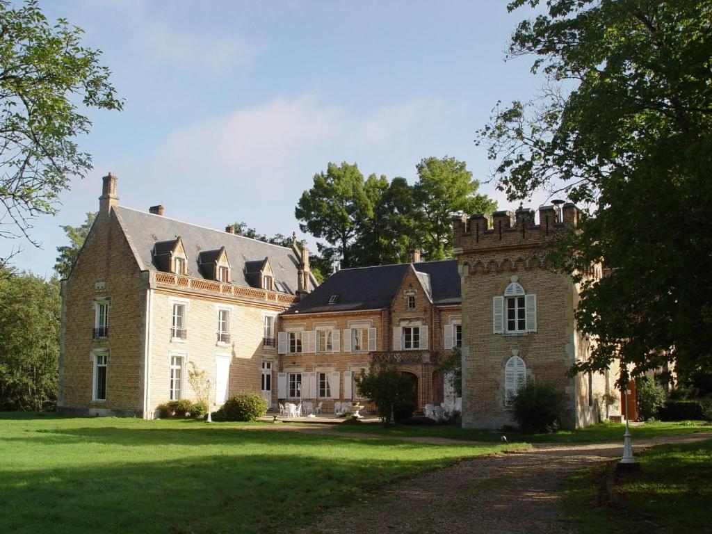 a large brick house with a grass yard at Hostellerie Du Ch&acirc;teau Les Muids in La Fert&eacute;-Saint-Aubin
