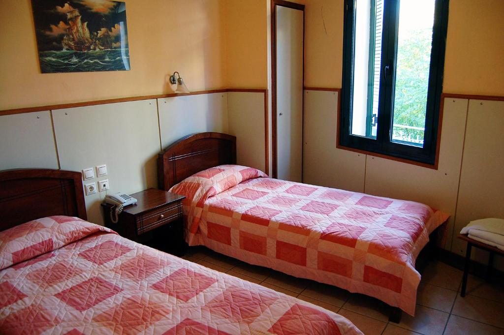 a bedroom with two beds and a window at Diethnes in Larisa