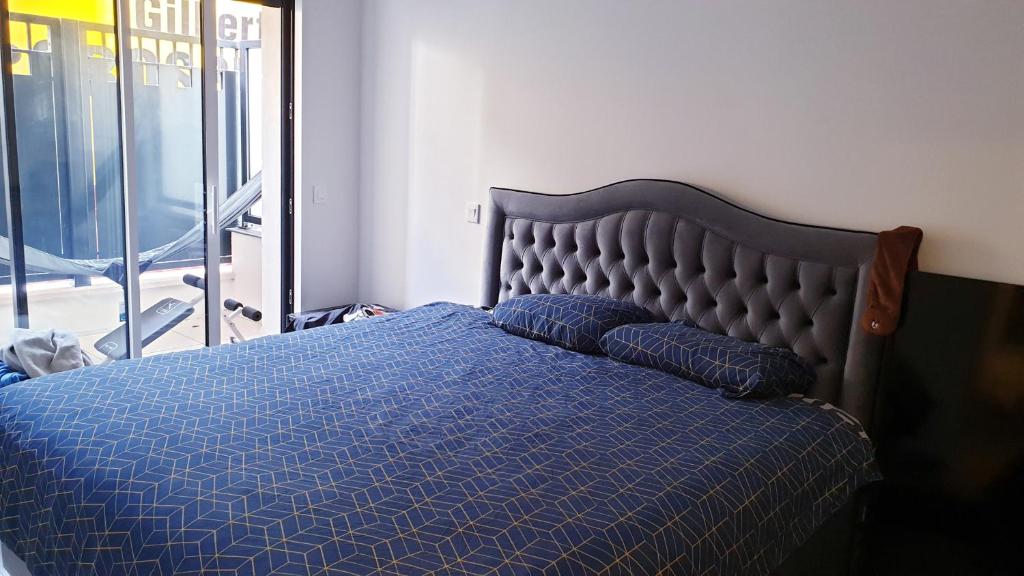 a bed with a blue comforter and two pillows at Appartment Porte de Versailles Paris Expo in Issy-les-Moulineaux